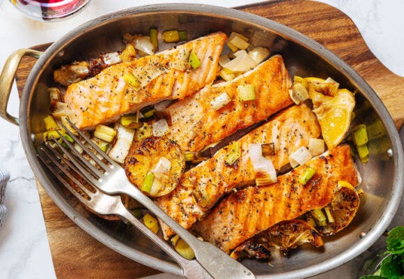 Pieces of grilled salmon with lemon on oval French pan
