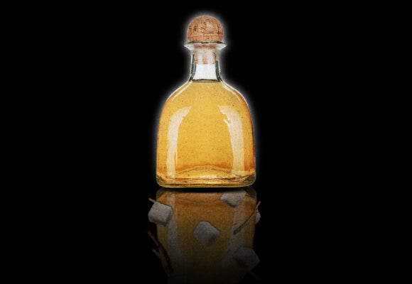 A tequila bottle with a reflection showing additives
