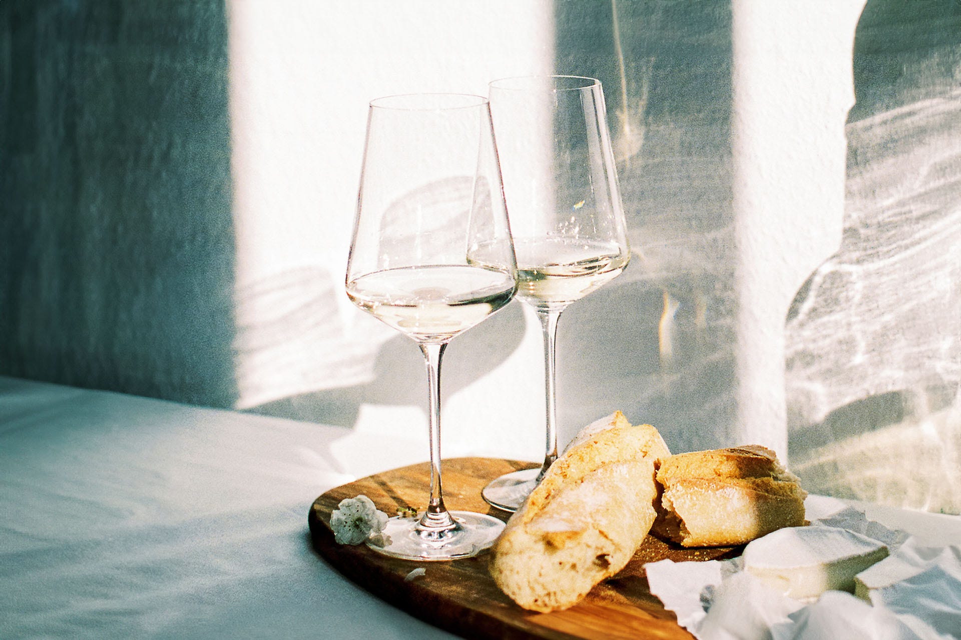wine with fresh french bread and cheese during sunset time indoors
