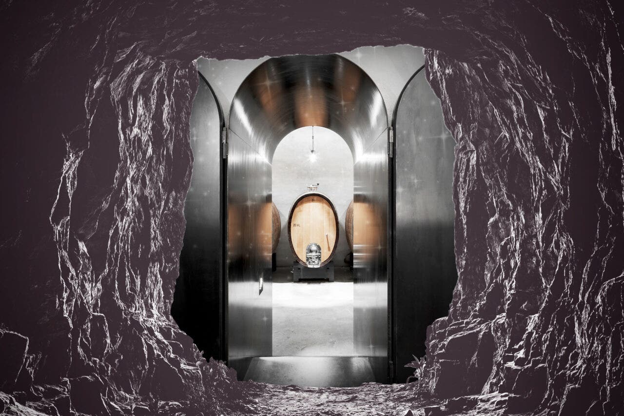 A cave with a whole leading into a wine cellar with a large barrel