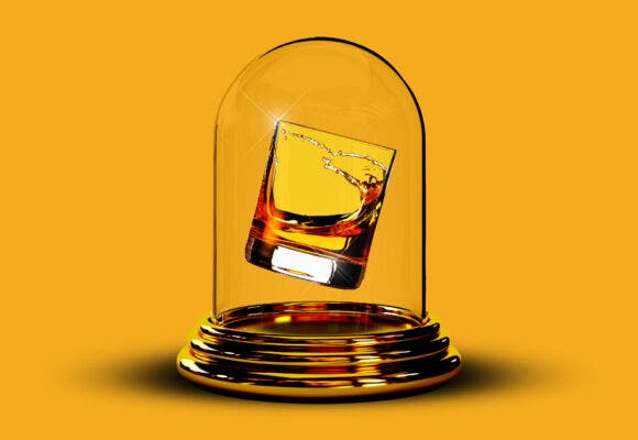 A glass of whiskey in a glass case