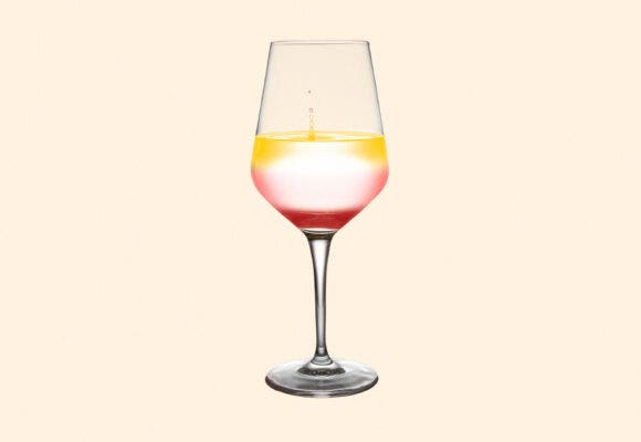 A wine glass full of 3 types of wine