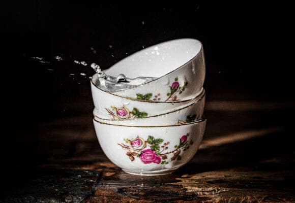 Sake splash on a little ceramic japanese cups - Flower decoration - Wooden table