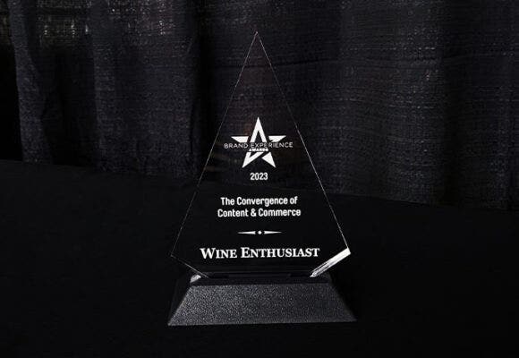 Clear triangular trophy sitting on top of black table.